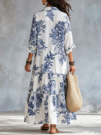 Lång blå boho-klänning med blommönster och knäppning.