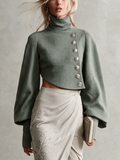 Chaqueta corta verde salvia con botonadura asimétrica y mangas abullonadas