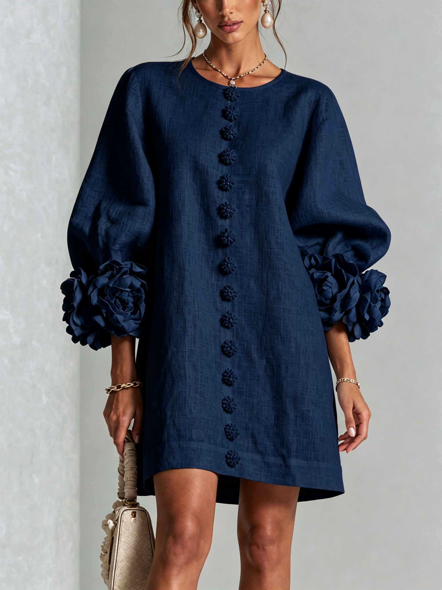 Miniklänning med blommigt tryck och knappar, med iögonfallande blomstermanschetter.
