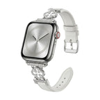 Correa Apple Watch para mujer en material sintético charolado, motivo trébol pavé de circonitas, aleación dorada elegante, modelo Circé